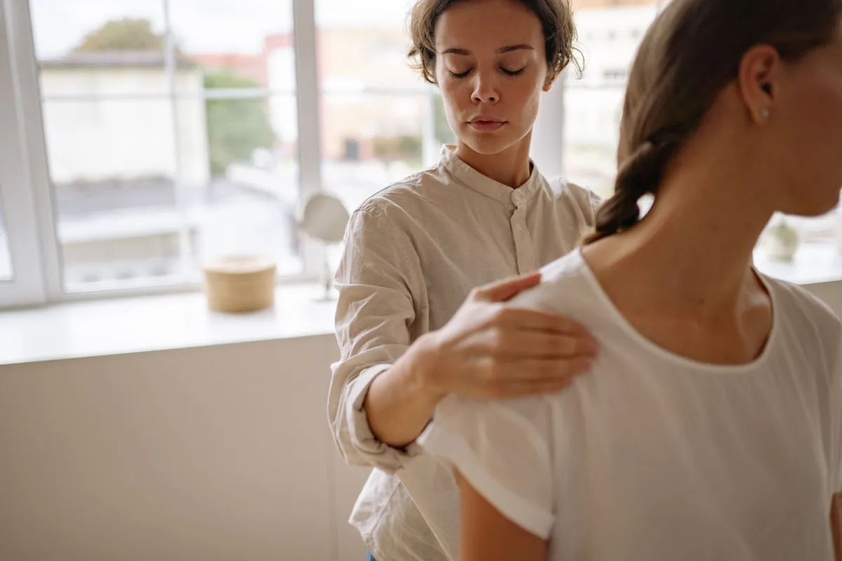A physiotherapist assists a client with treatment in a bright, modern clinic, highlighting specialized care.