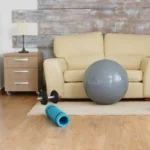 An empty room featuring an elliptical machine and a fitness ball, highlighting specialized physical therapy equipment.